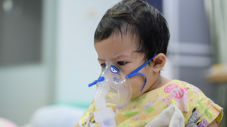 young child wearing oxygen mask