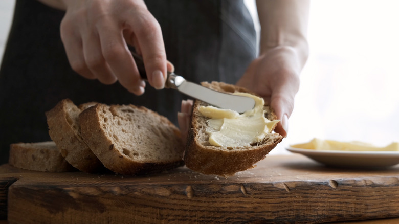 woman spreading butter on bread