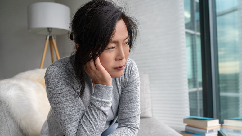 A sad woman leaning her head on her hand