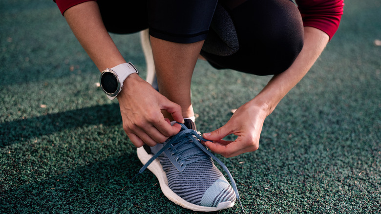 woman lacing up her running shoes