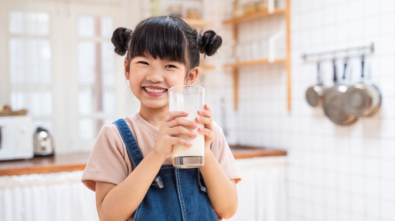 Asian child holding a glass of milk