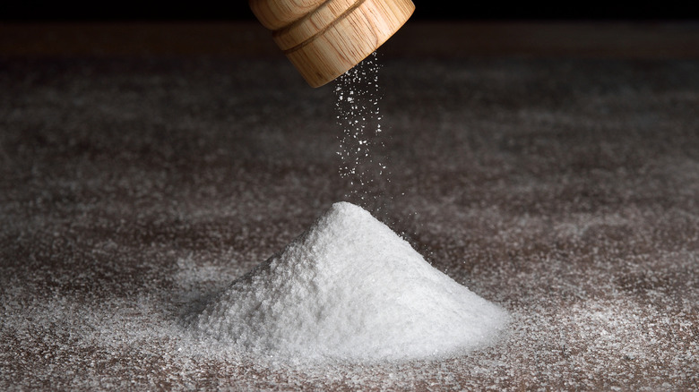 Salt grinder over a pile of table salt