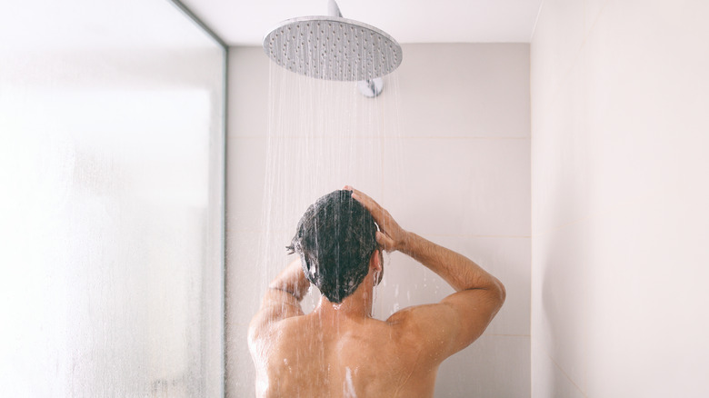 Man showering and rinsing hair