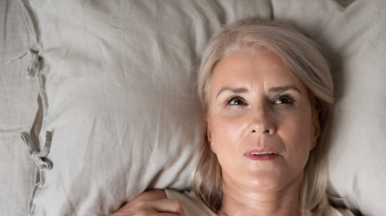 woman laying in bed nervous