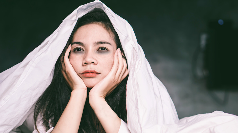 woman in bed with dark circles cant sleep
