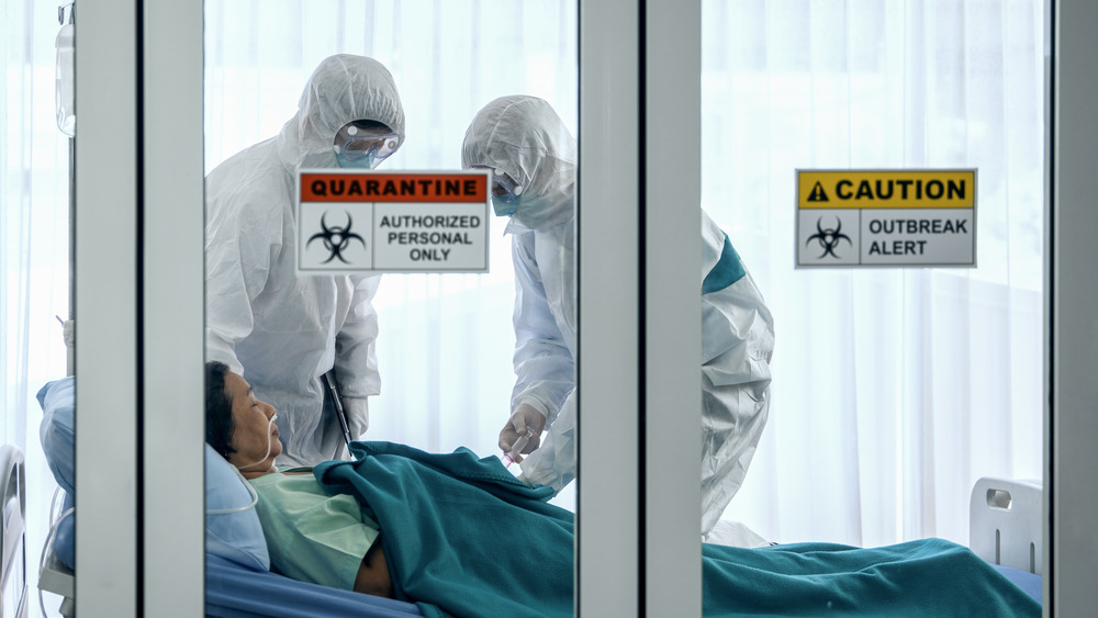 coronavirus covid 19 infected patient in quarantine room with quarantine and outbreak alert sign at hospital.