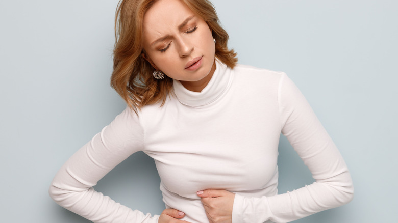 WOMAN PRESSING ON ABDOMEN IN PAN