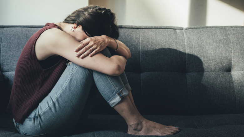 Woman with head in knees