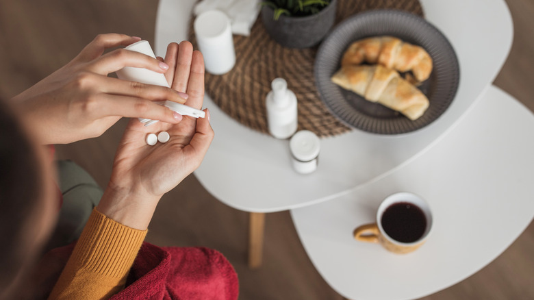 Woman taking pills with coffee