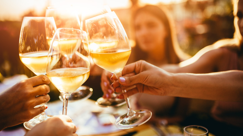 group clinking wine glasses together