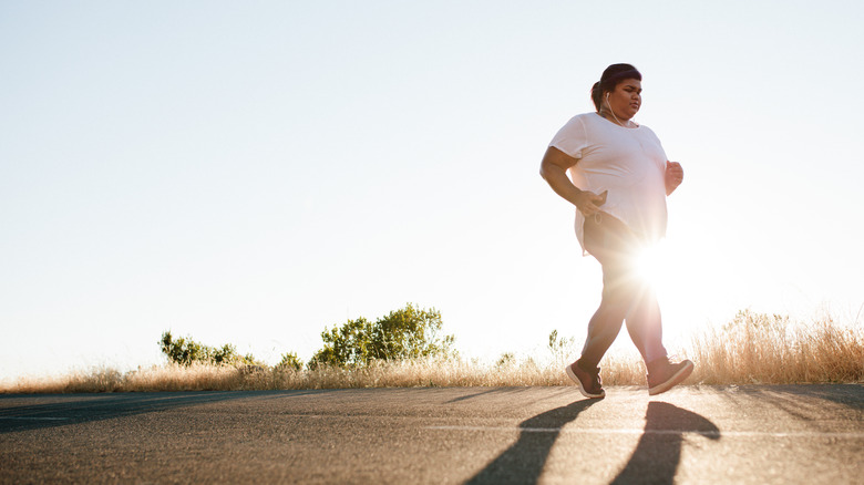 plus-sized woman jogging outside