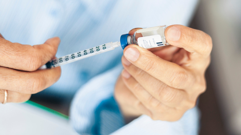 Man with insulin bottle and needle