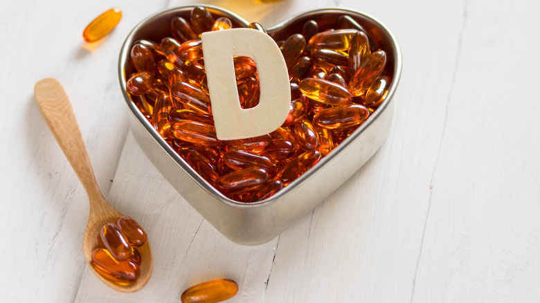 Supplements in heart container and on wooden spoon 
