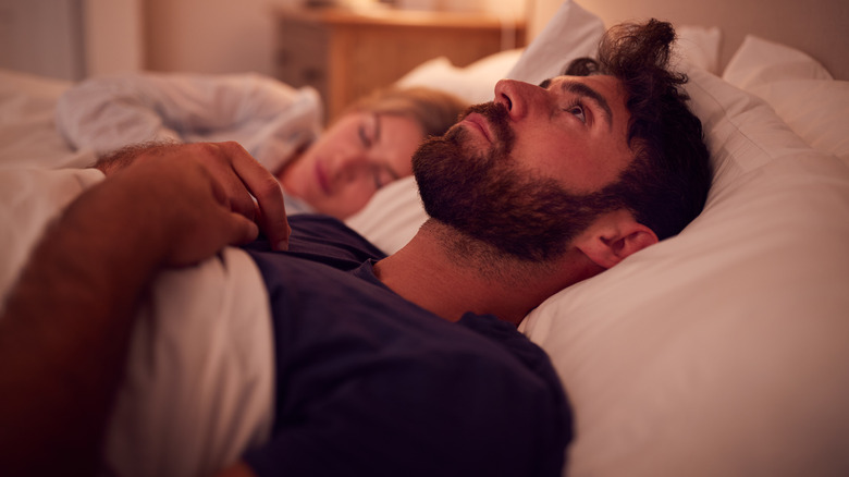 Worried man laying in bed