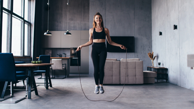 A woman jumping rope at home