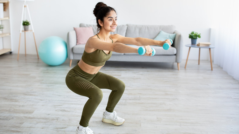 A woman squats during a workout