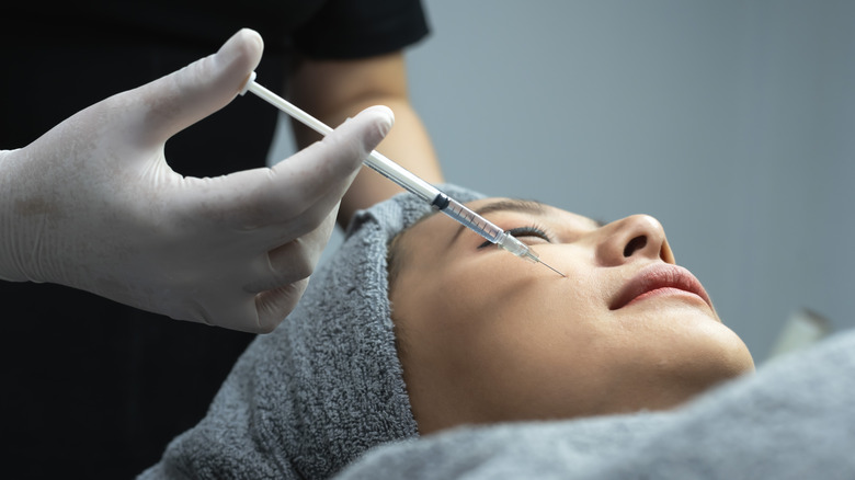 woman getting a dermal filler injection at clinic