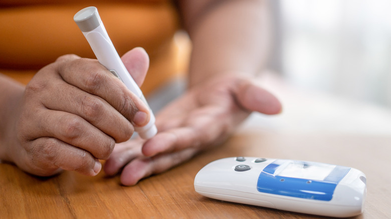 A woman checking her blood sugar with a monitor