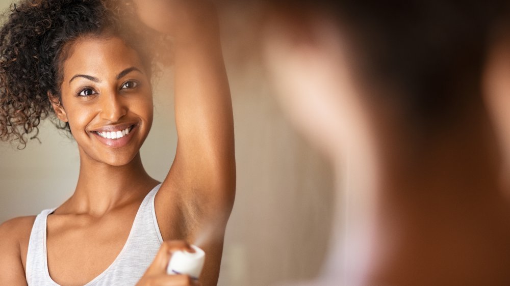 woman applying deodorant