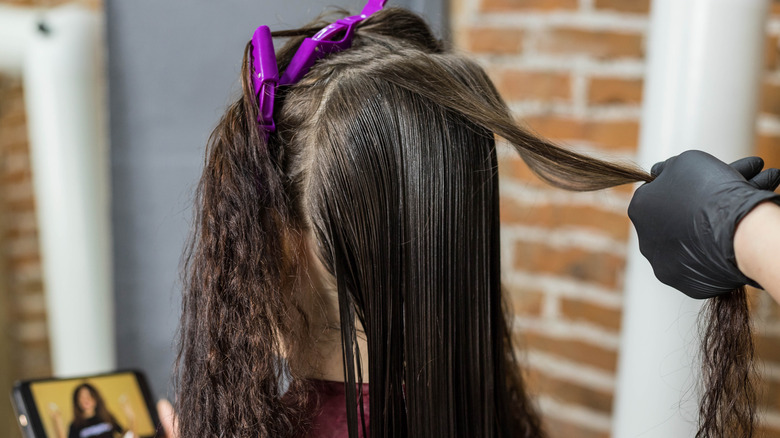 Woman receiving keratin treatment in salon