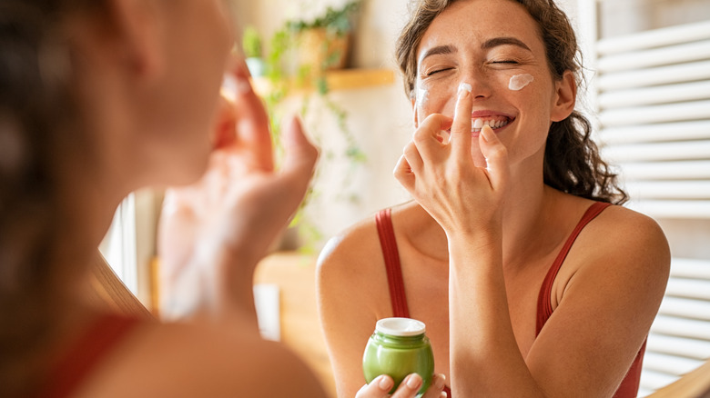 woman moisturizing her skin