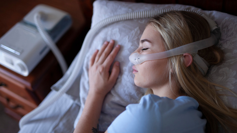 Young woman sleeping with CPAP machine