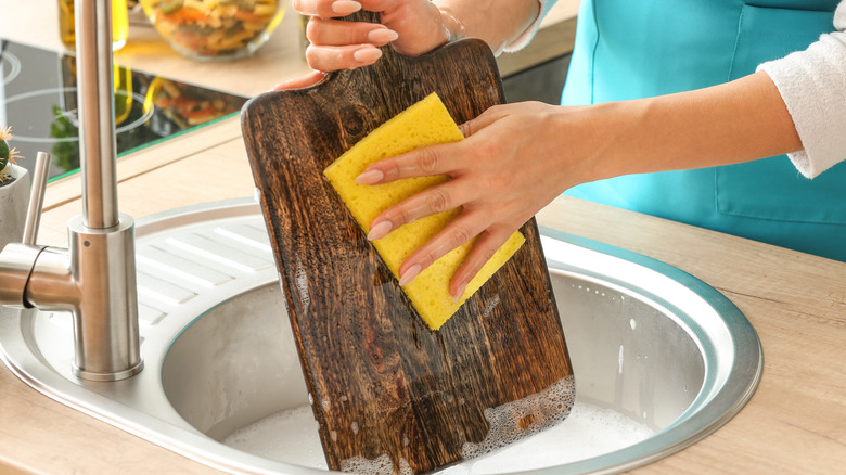 person cleaning with a sponge in the kitchen