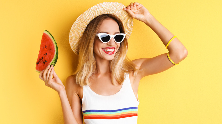 Woman in summer attire holding watermelon slice