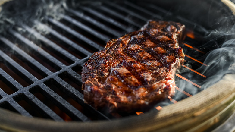 Charred piece of meat on a grill 