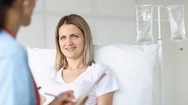 Hospitalized woman speaking to doctor