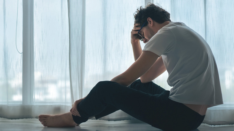 Sad Man sitting on floor head in hands