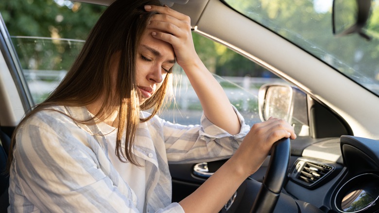 Woman with migraine in driver seat