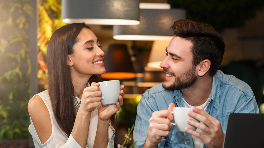 Young couple flirting and drinking coffee