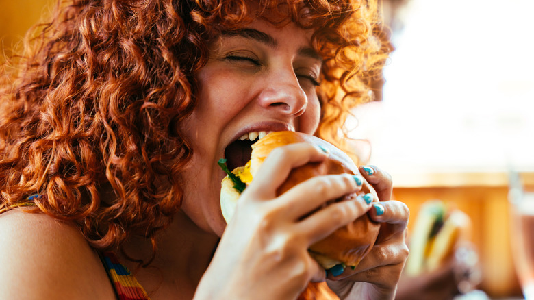 A woman enjoying a fast food burger