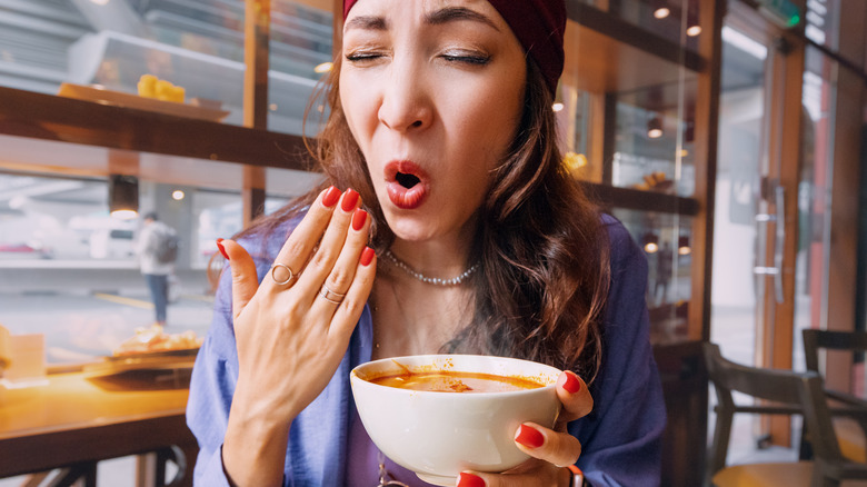Woman eating fiery hot soup
