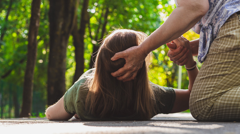 woman assisted on ground after falling