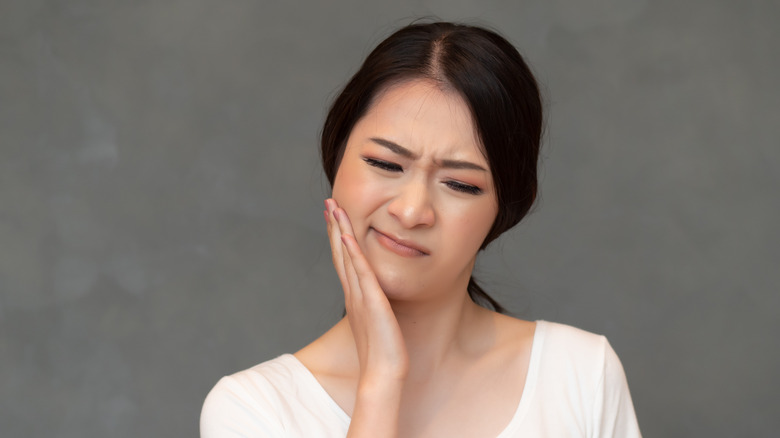 A woman has a toothache on the side of her face