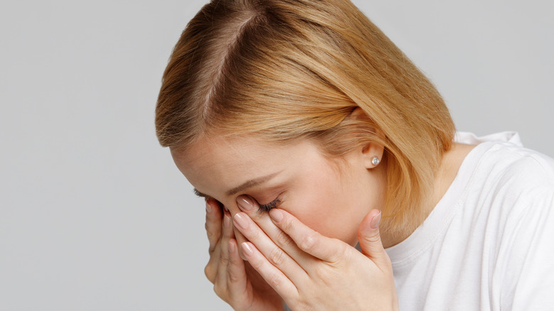 Woman rubbing her eyes in discomfort