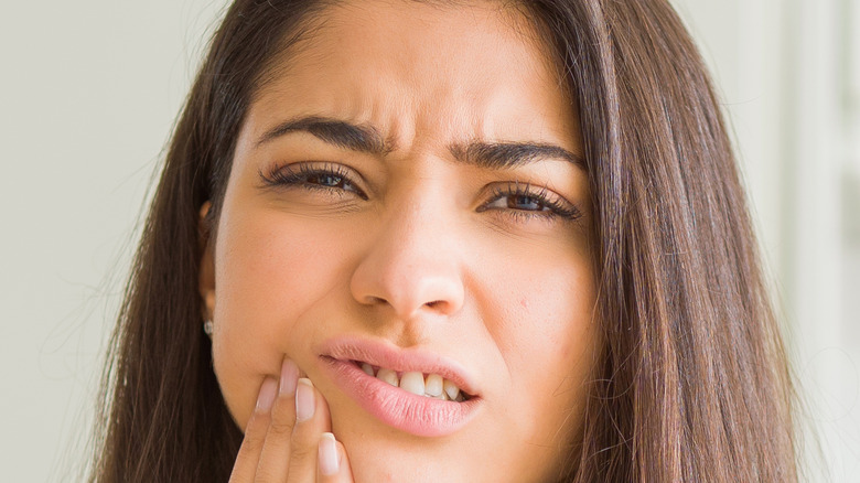 woman putting hand on face for toothache