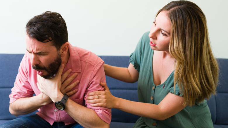 Woman helping man who is choking