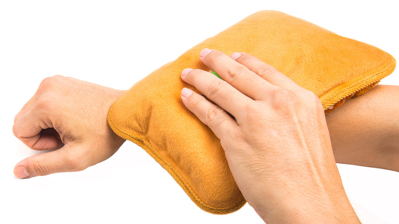 person applying a warm compress