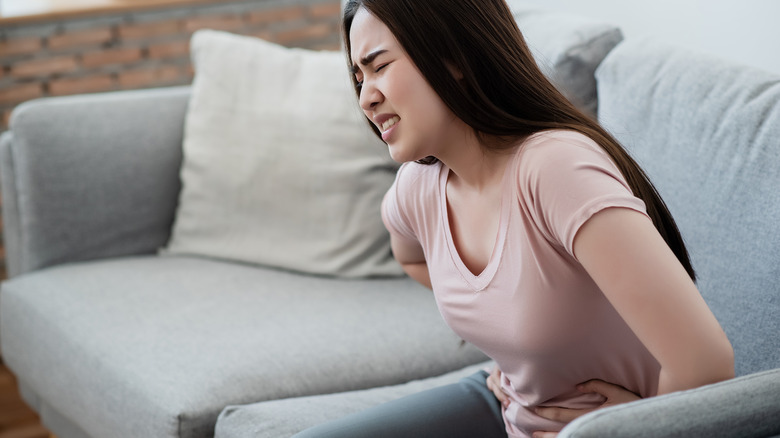 woman clutches her stomach