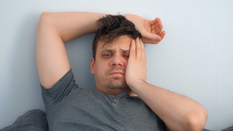 exhausted man rubbing face