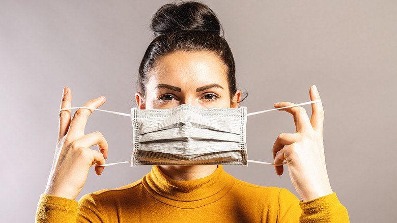 woman putting on mask