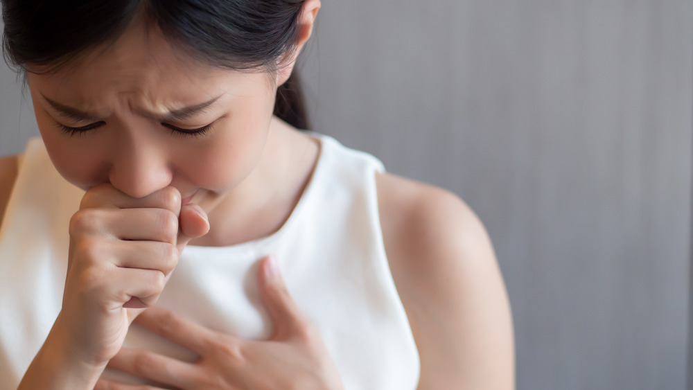 Young woman holding throat choking