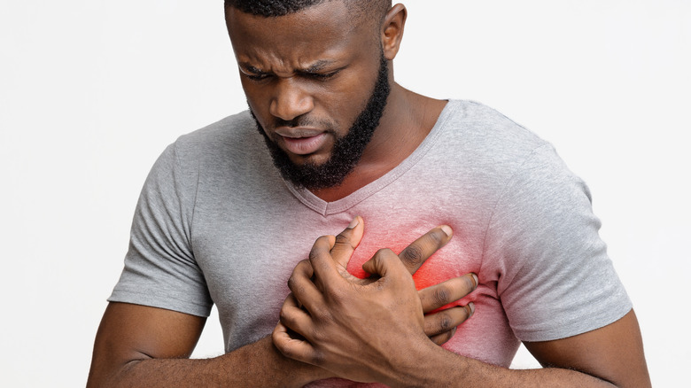 A young man pressing his hand to his chest