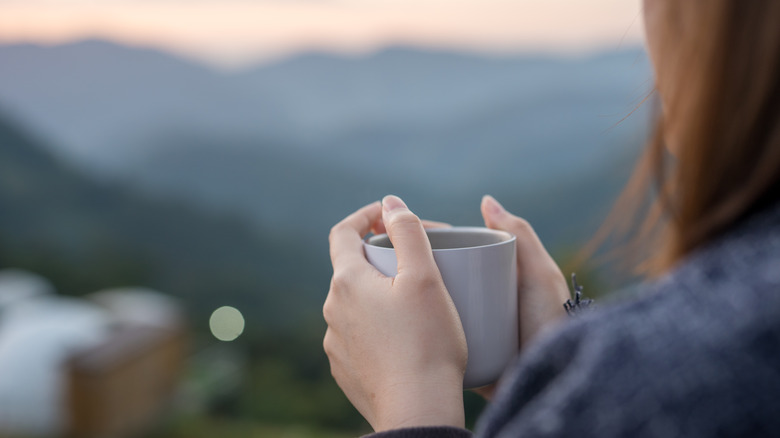 Person holding cup of coffee