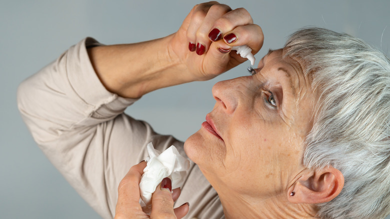 older woman using eye drops 