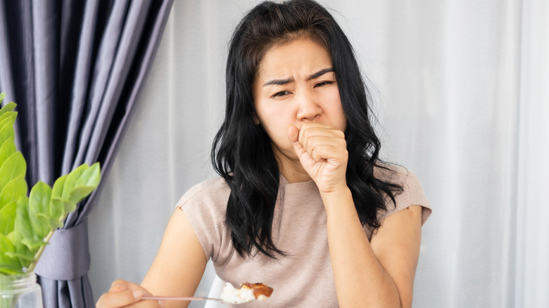 Burping woman covering mouth