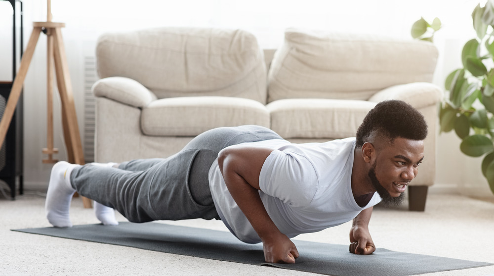 young man planking in his living room